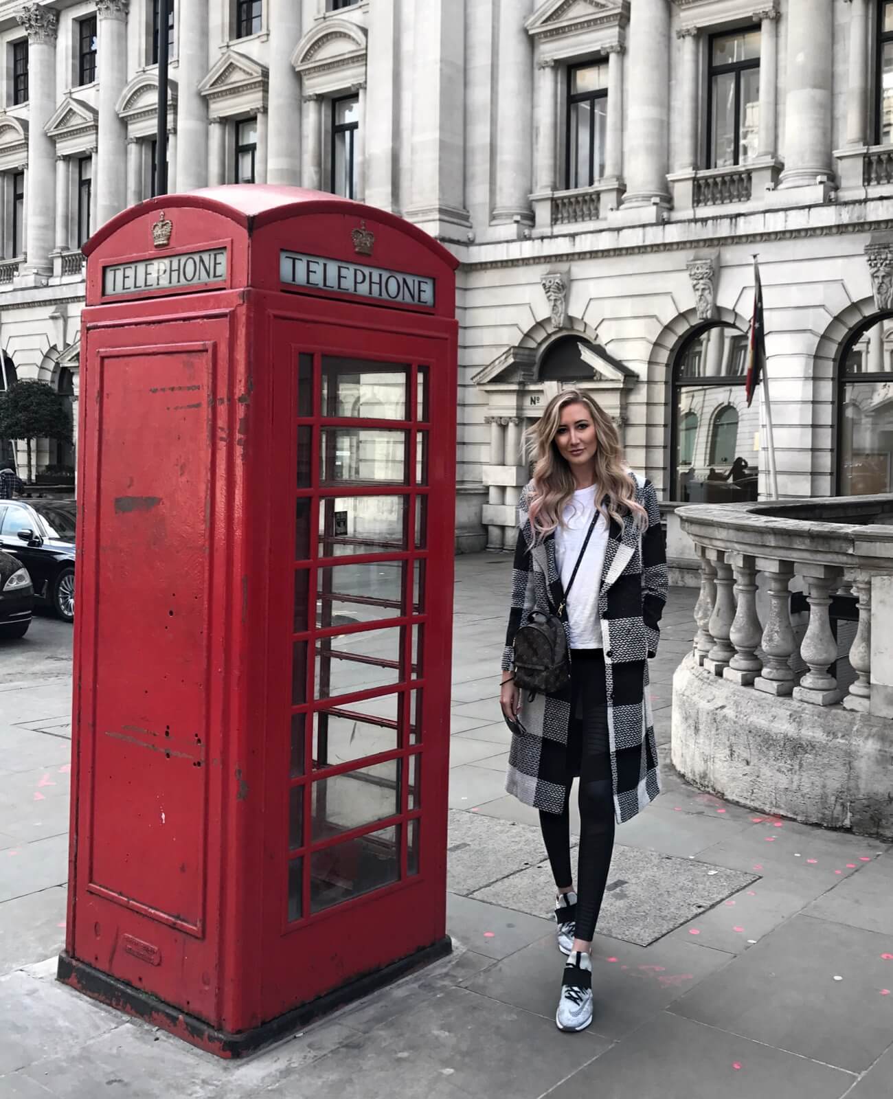 Carly Cristman in London wearing a plaid coat with nike air zoom sneakers and moto leggings